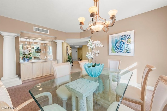 2619 Wulfert Rd Unit 5, Sanibel, FL 33957 - dining room featuring decorative columns, a chandelier, and light carpet