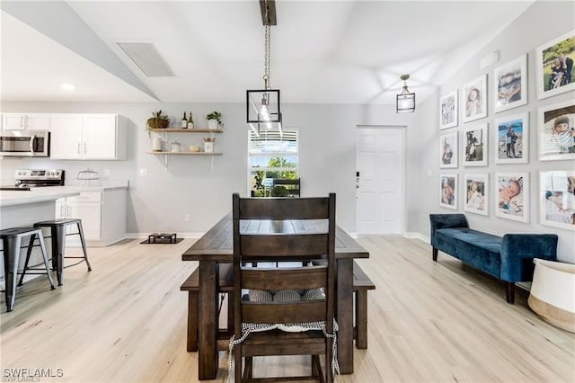 dining area with lofted ceiling and light hardwood / wood-style floors