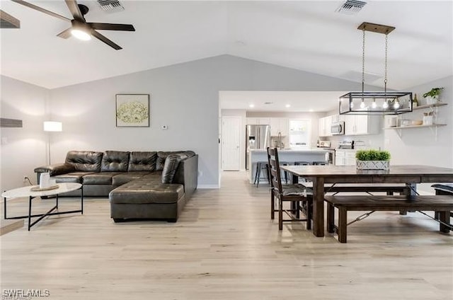 dining area featuring ceiling fan, lofted ceiling, and light hardwood / wood-style floors