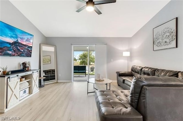 living room with ceiling fan, vaulted ceiling, and light hardwood / wood-style flooring