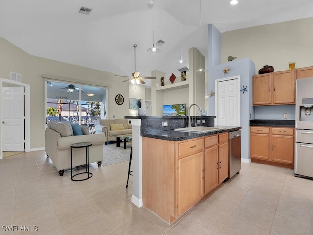 kitchen with sink, a breakfast bar area, high vaulted ceiling, a center island with sink, and stainless steel appliances