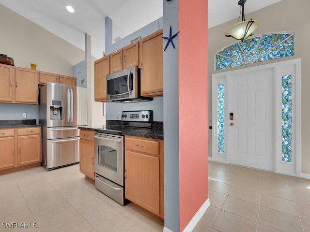 kitchen featuring light brown cabinets, appliances with stainless steel finishes, light tile patterned floors, and high vaulted ceiling