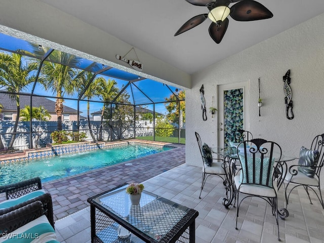 view of swimming pool with a patio area, pool water feature, ceiling fan, and glass enclosure