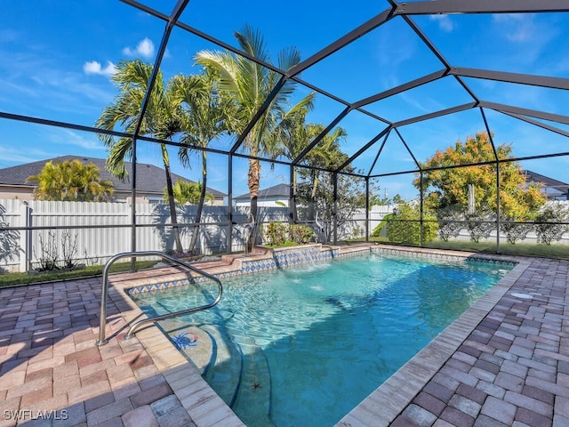 view of swimming pool with pool water feature, a patio, and glass enclosure