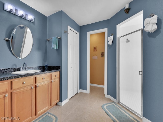 bathroom featuring tile patterned flooring, vanity, and a shower with door