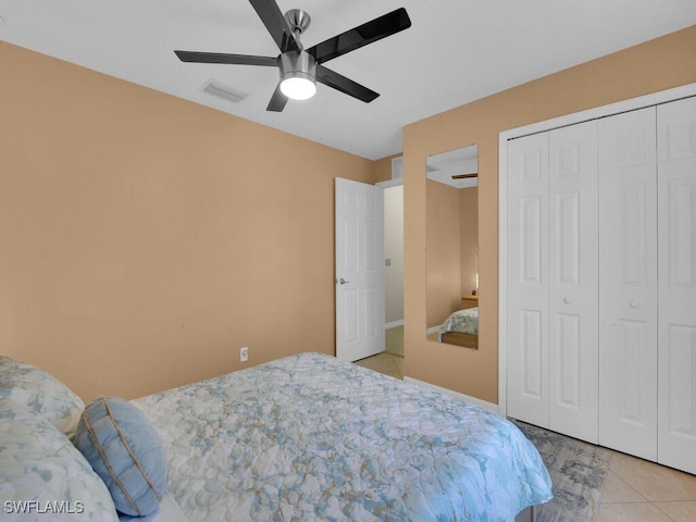 bedroom with light tile patterned floors, ceiling fan, and a closet