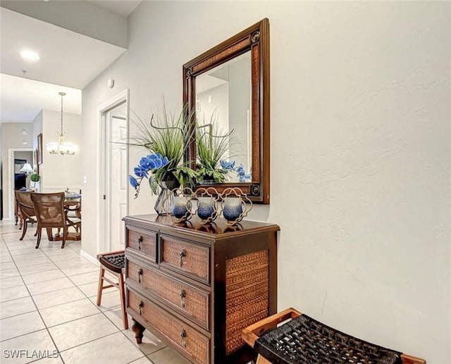 corridor featuring a notable chandelier and light tile patterned floors