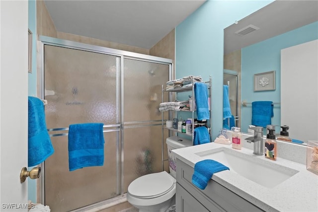 bathroom featuring vanity, toilet, and an enclosed shower