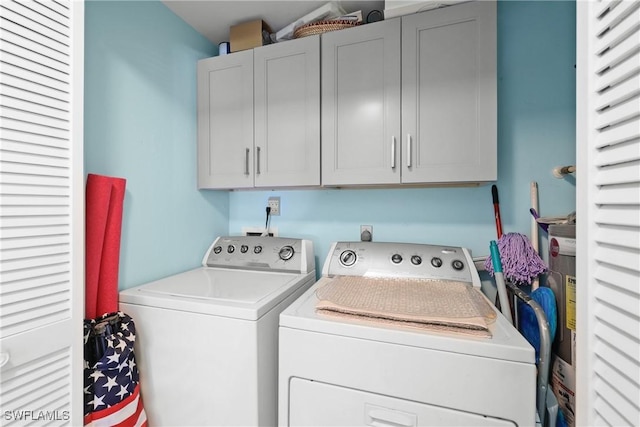 washroom featuring washer and clothes dryer and cabinets