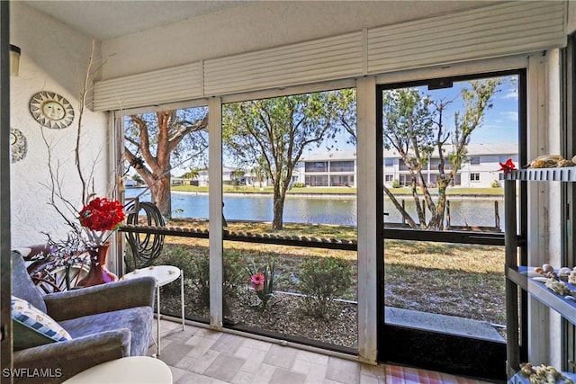 sunroom / solarium with a water view and a healthy amount of sunlight