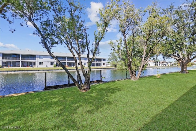 dock area with a lawn and a water view