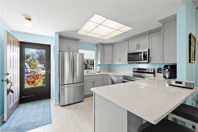 kitchen featuring a kitchen bar, kitchen peninsula, and appliances with stainless steel finishes