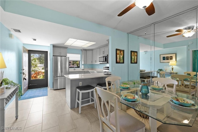 dining room featuring light tile patterned floors, sink, and ceiling fan