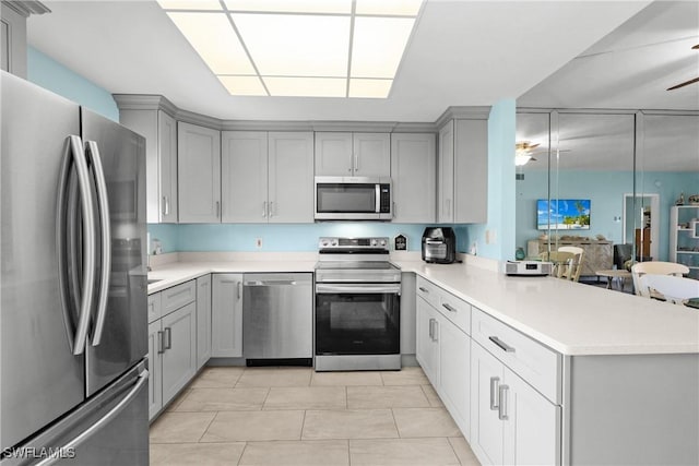 kitchen featuring appliances with stainless steel finishes, gray cabinets, kitchen peninsula, and light tile patterned floors