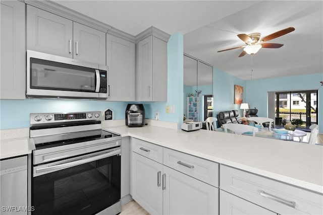 kitchen with stainless steel appliances, kitchen peninsula, and ceiling fan