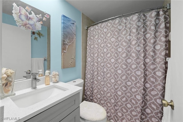 bathroom featuring walk in shower, vanity, and toilet