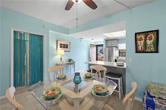 dining space with ceiling fan and light hardwood / wood-style flooring