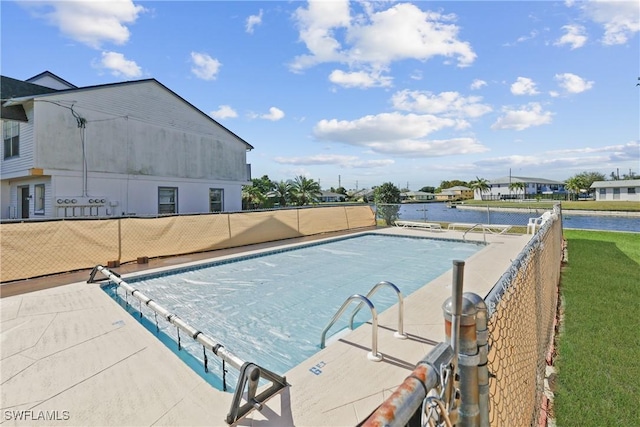 view of pool with a water view and a patio