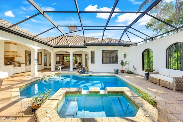 view of pool with an outdoor living space, a patio area, glass enclosure, and an outdoor kitchen