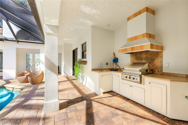 view of patio / terrace featuring sink, french doors, a grill, and an outdoor kitchen