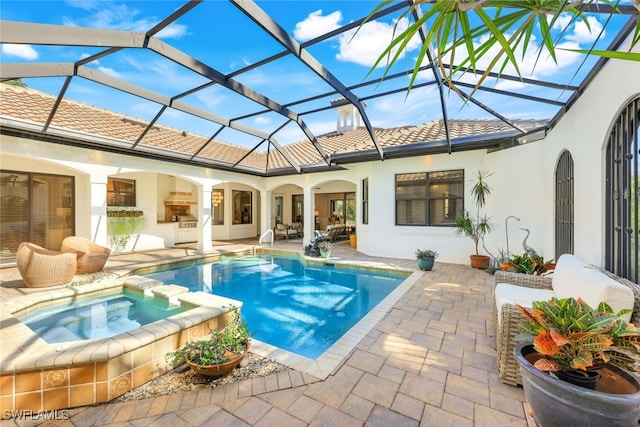 view of swimming pool featuring a patio, a lanai, exterior kitchen, and an in ground hot tub