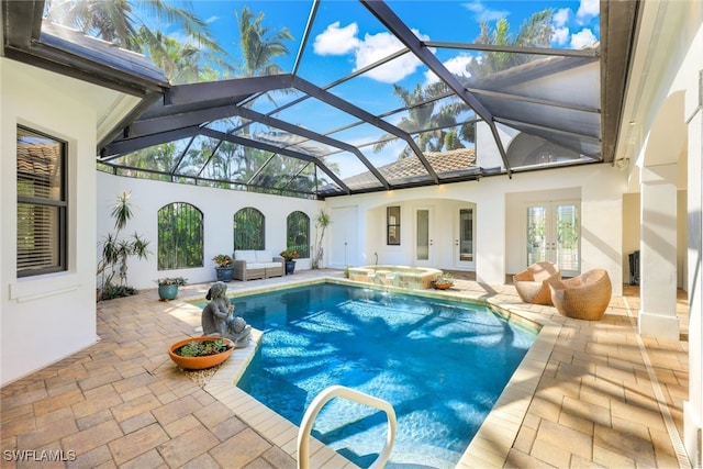 view of swimming pool featuring an in ground hot tub, a lanai, a patio area, and french doors