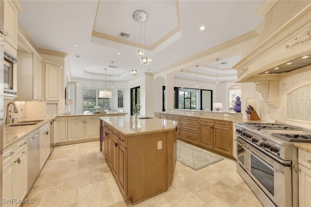 kitchen featuring stainless steel appliances, a raised ceiling, and kitchen peninsula