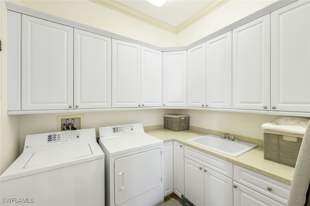 clothes washing area featuring cabinets, crown molding, sink, and independent washer and dryer