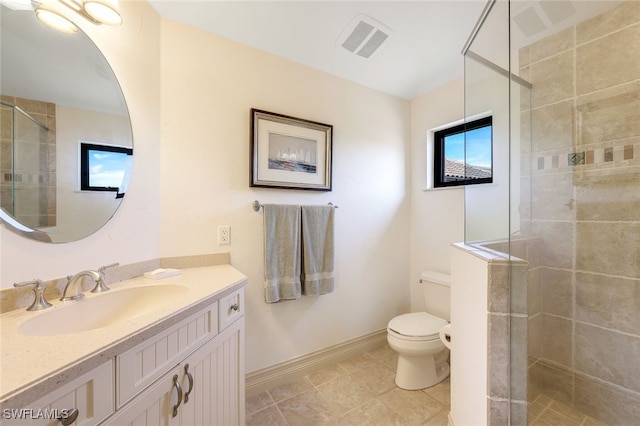 bathroom featuring tile patterned floors, vanity, toilet, and a shower with shower door