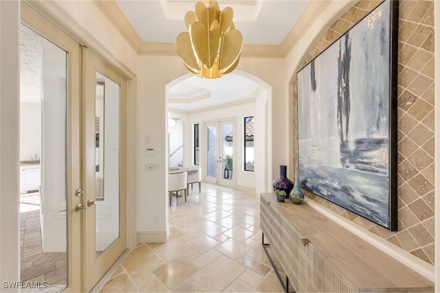 hall with a tray ceiling, crown molding, and french doors