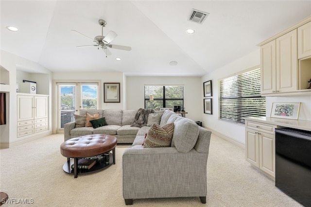 living room with light carpet, vaulted ceiling, and ceiling fan