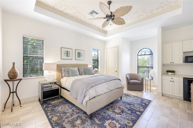 bedroom with a raised ceiling, crown molding, and ceiling fan