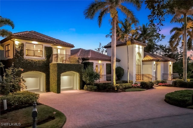 mediterranean / spanish-style home with a garage and a balcony