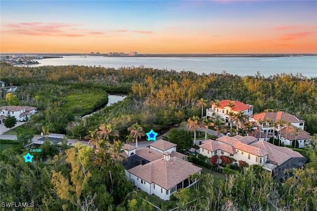 aerial view at dusk featuring a water view