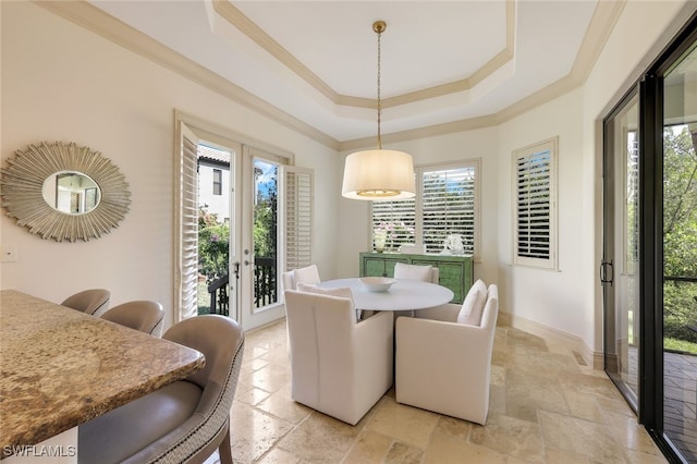 dining room featuring crown molding, a raised ceiling, and french doors