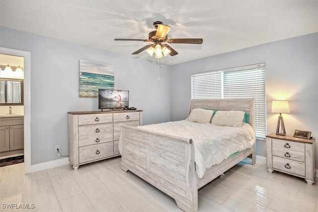 bedroom featuring ceiling fan, sink, and ensuite bath