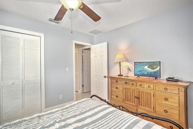 bedroom with ceiling fan, a closet, and a textured ceiling