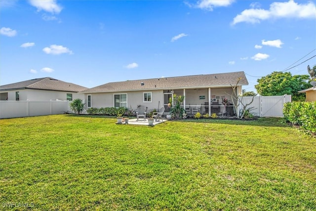 back of house featuring a lawn and a patio area