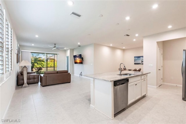 kitchen with sink, white cabinets, a kitchen island with sink, light stone counters, and stainless steel appliances