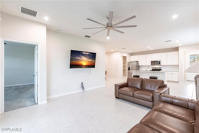 living room featuring ceiling fan and sink