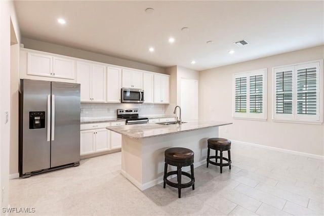 kitchen featuring a kitchen island with sink, sink, white cabinets, and appliances with stainless steel finishes