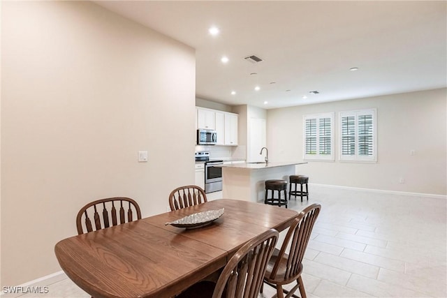 tiled dining room featuring sink