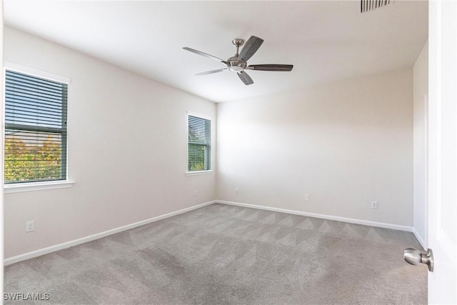 empty room with light carpet, ceiling fan, and a healthy amount of sunlight