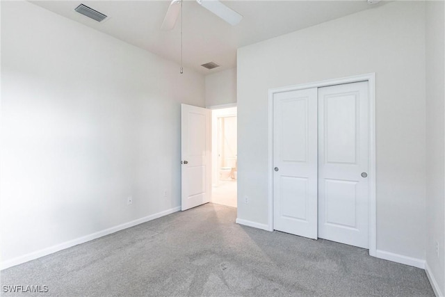 unfurnished bedroom featuring light colored carpet, ceiling fan, and a closet