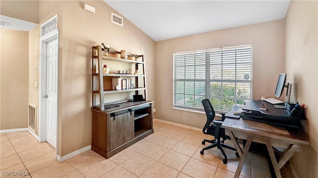 home office with light tile patterned flooring and vaulted ceiling