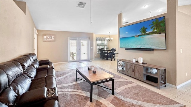 living room with french doors, a chandelier, and light tile patterned floors