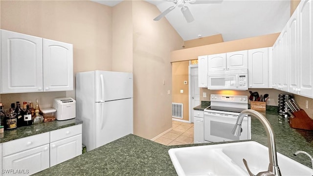 kitchen with sink, white appliances, light tile patterned floors, white cabinetry, and vaulted ceiling