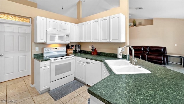 kitchen with vaulted ceiling, light tile patterned flooring, white cabinetry, sink, and white appliances