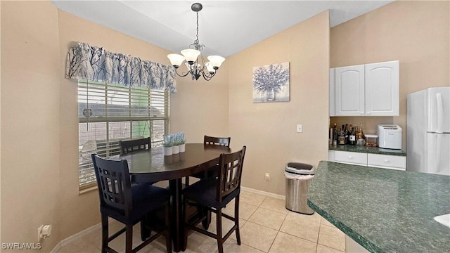 dining area featuring lofted ceiling, light tile patterned floors, and a notable chandelier