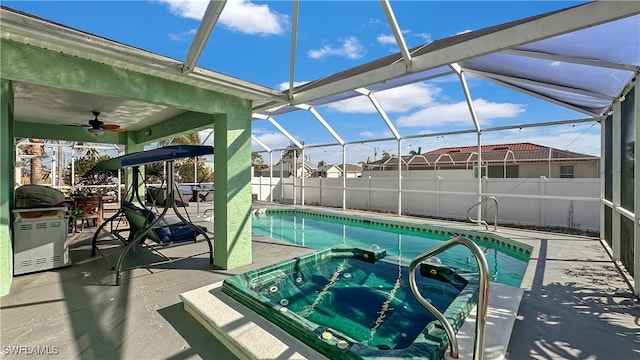 view of swimming pool featuring ceiling fan, a lanai, and a patio